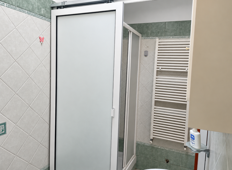 Bagno luminoso con doccia e piastrelle decorative