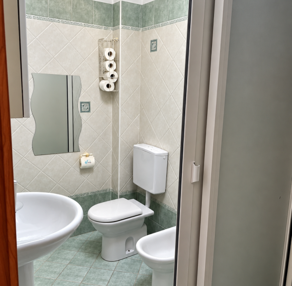 Bagno verde con sanitari bianchi
