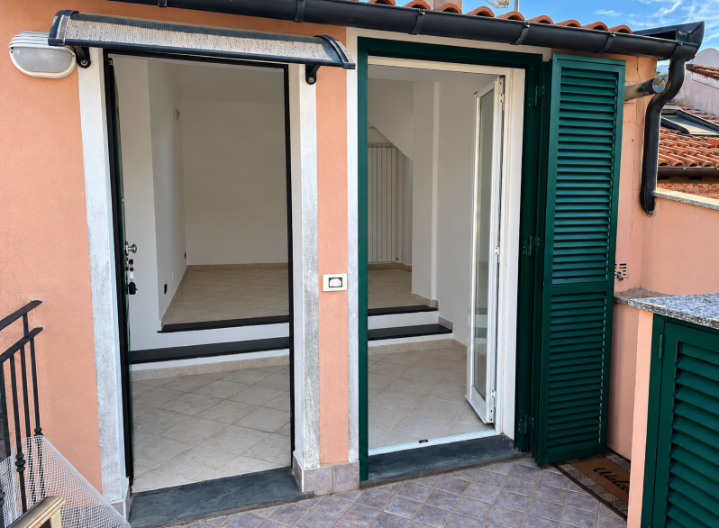 Ingresso terrazzato con persiane verdi